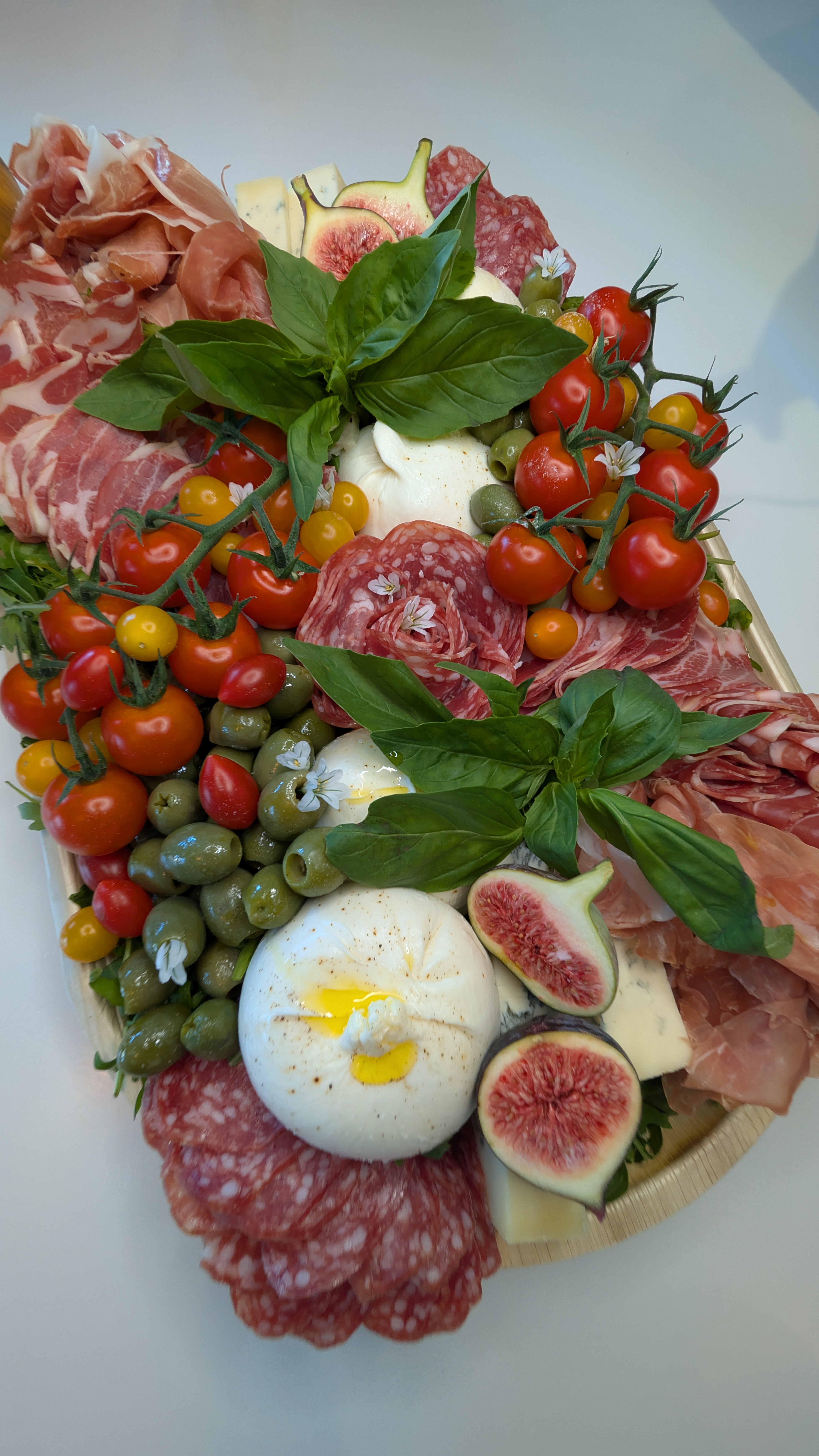 Italian antipasto board with burrata, basil, salami and cherry tomatoes