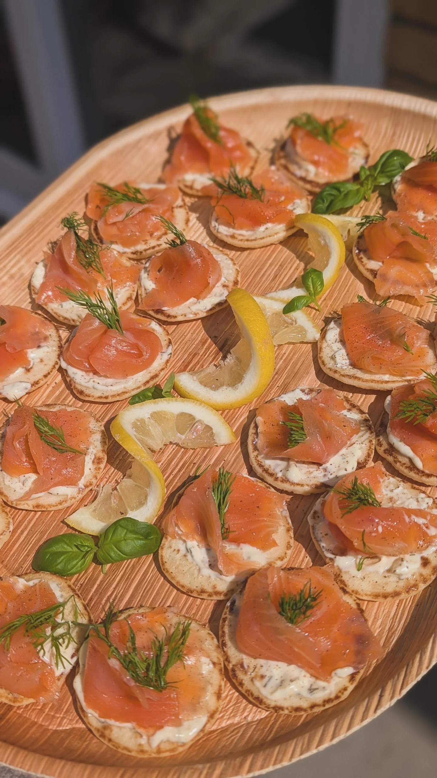Smoked salmon blinis with dill on a wooden tray
